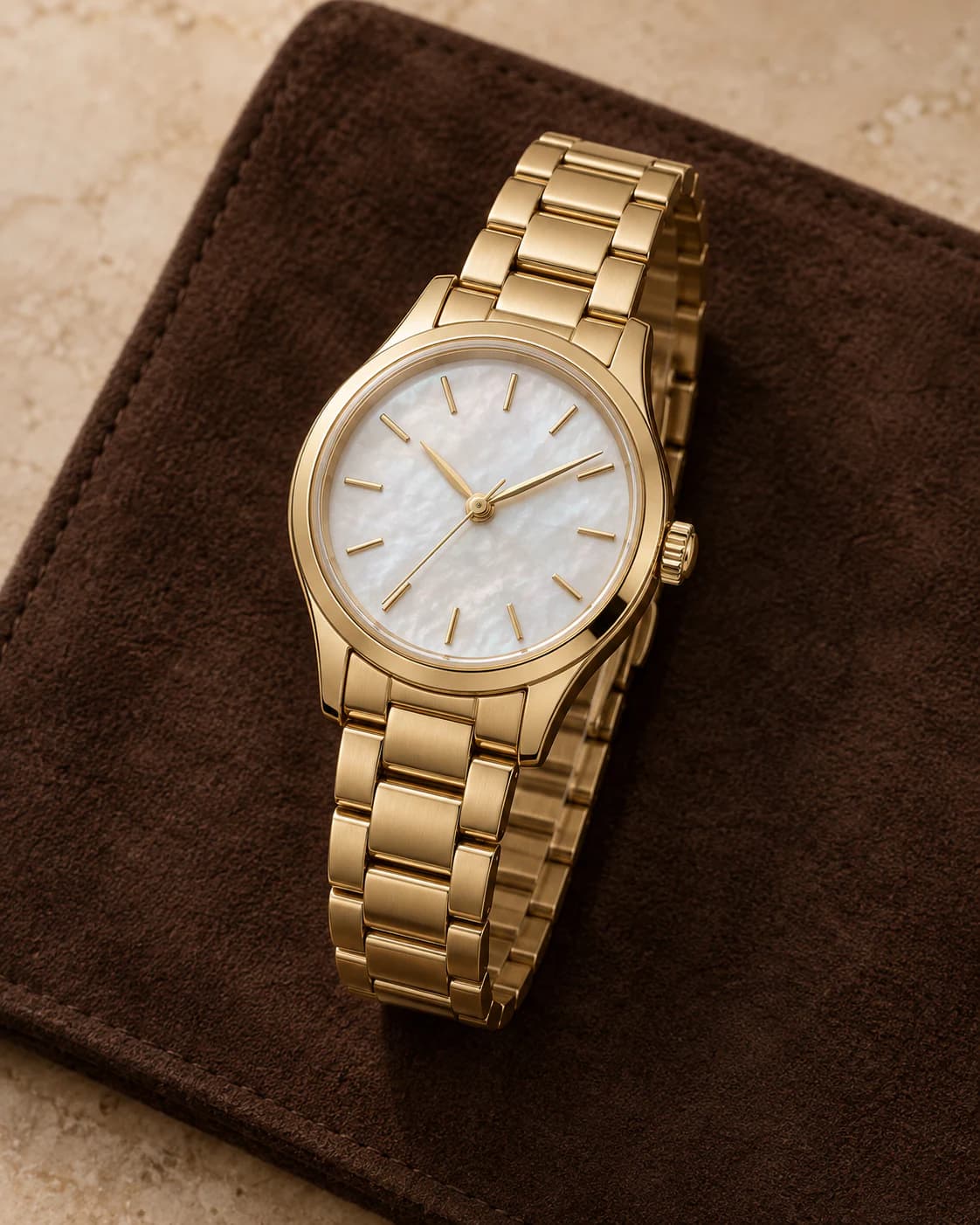 Lumière Petite 28mm in gold-tone with a mother-of-pearl dial, front view on a plain champagne background