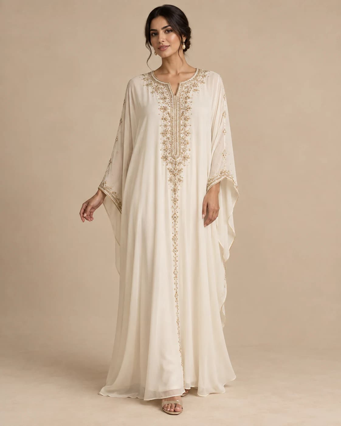Noor Embellished Kaftan in ivory chiffon with gold beading, front view on a plain champagne background