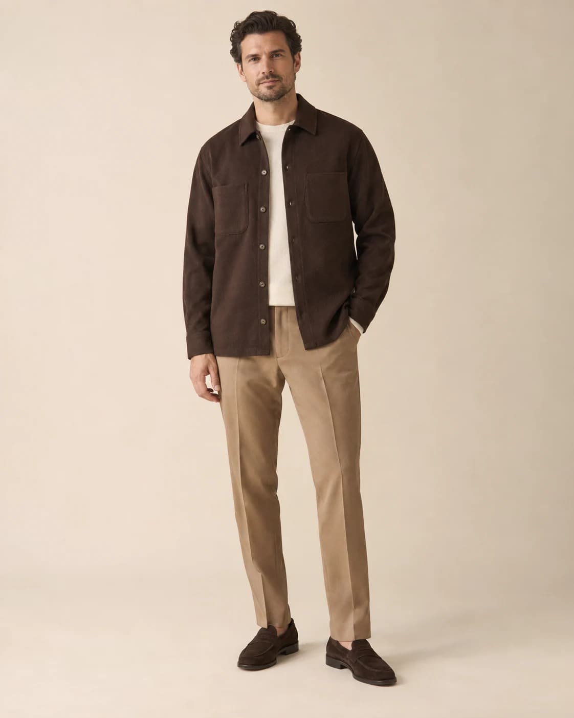 Cassius Merino Overshirt in chocolate merino, front view on a plain champagne background